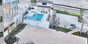 An aerial view of a hotel with a swimming pool, lounge area, and parking lot. - 🌊Beach Front with Great Views-Pool+Hot Tub-Pelican Watch #602🌊 (Fort Myers Beach)