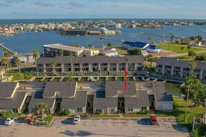 A hotel with a central courtyard, multiple floors, and a view of the ocean.