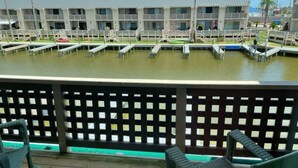 A hotel with a pool area, outdoor seating, and a view of the water.