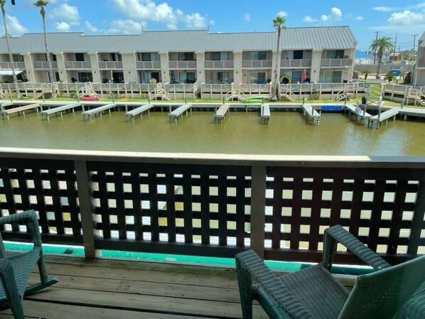 Un hotel con piscina, mobiliario exterior y vistas al agua.