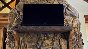 Una chimenea de piedra con un televisor de pantalla plana montado encima.