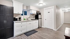 A modern kitchen with white cabinets, a black refrigerator, and a coffee maker. - Judkins Retreat - Close to Downtown (Seattle)