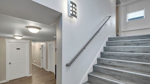 A staircase with a metal handrail leading to a landing. - Judkins Retreat - Close to Downtown (Seattle)