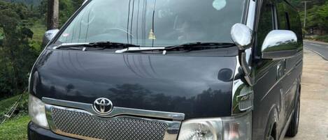 A black Toyota van parked on a road with a license plate reading "EP PG 0444".