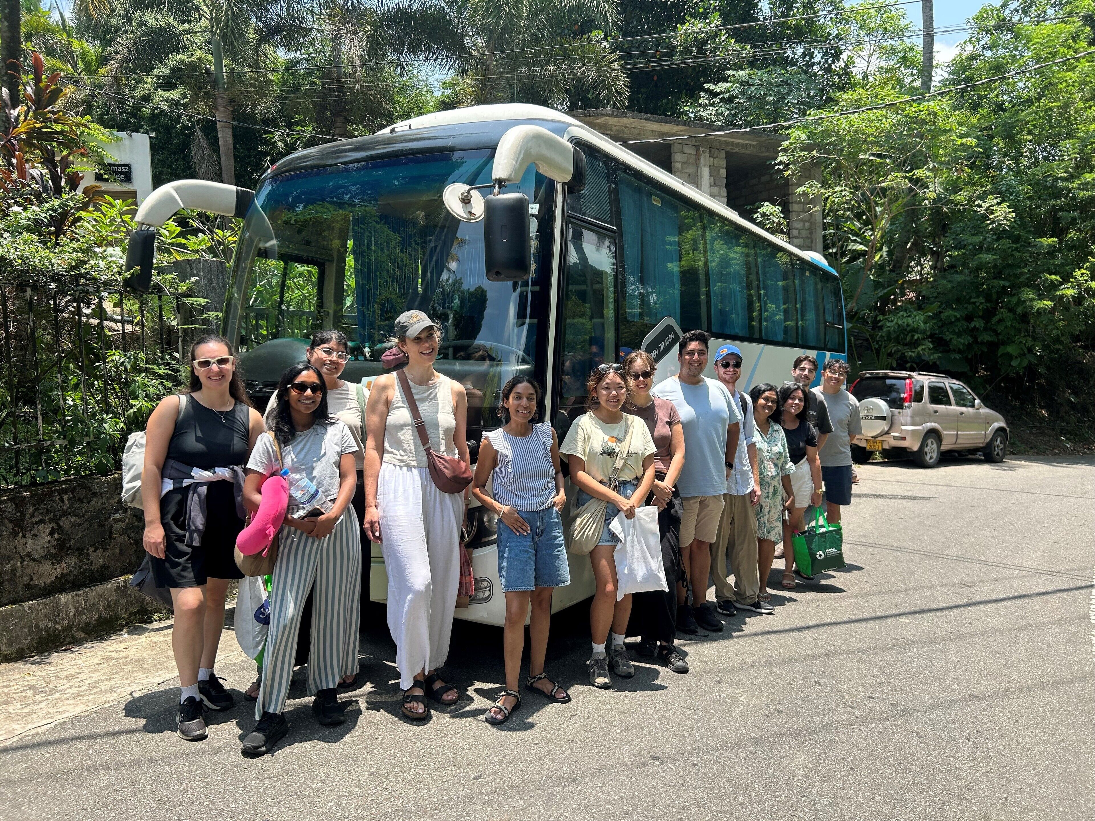 A group of people standing in front of a bus.