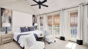 A bedroom with a bed, bedside tables, a ceiling fan, and large windows with curtains. - North Winston Villa|Easy Beach Access|Private Pool & Golf Cart (Inlet Beach)
