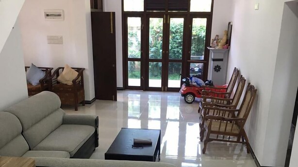Una sala moderna con un sofá, una mesa de centro y una zona de comedor con sillas de madera.