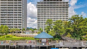 A waterfront hotel with a gazebo, a dock, and a large building in the background.