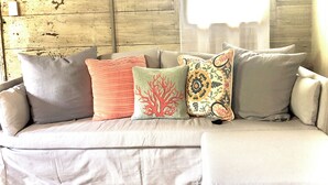 A beige sofa with patterned cushions and a geometric rug. - Charming historic cottage in Enoree (Enoree)