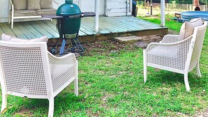 A house with a porch, a grill, and two wicker chairs. - Charming historic cottage in Enoree (Enoree)