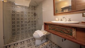 Une salle de bain avec une douche à parois de verre, des toilettes et un lavabo avec un meuble-vasque en bois.
