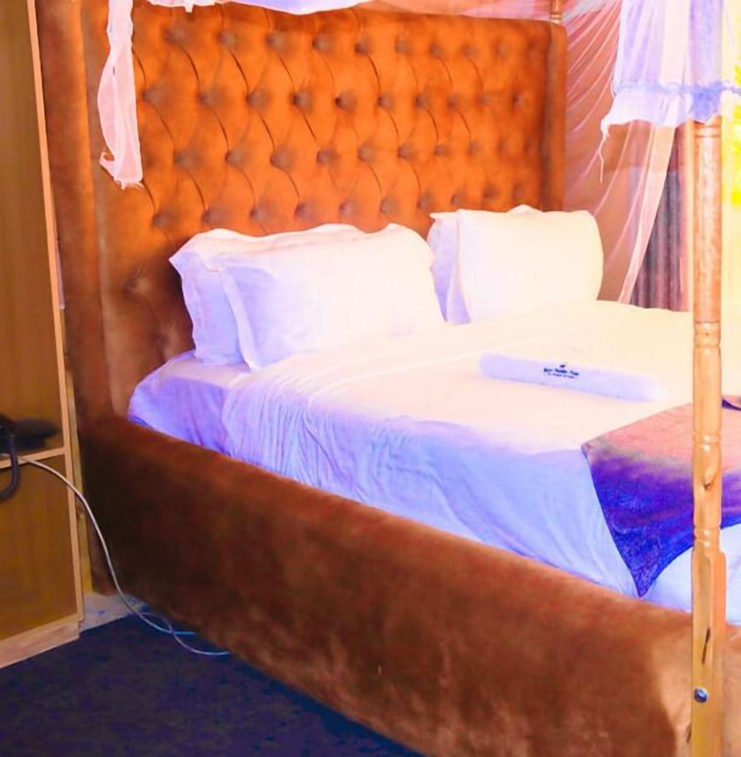 A bed with a tufted headboard, white bedding, and a wooden frame.