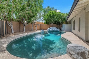 A swimming pool with clear water, surrounded by a brick wall and trees. - Family friendly oasis 4 bedrm 2 bathrm 4 beds (Mesa)