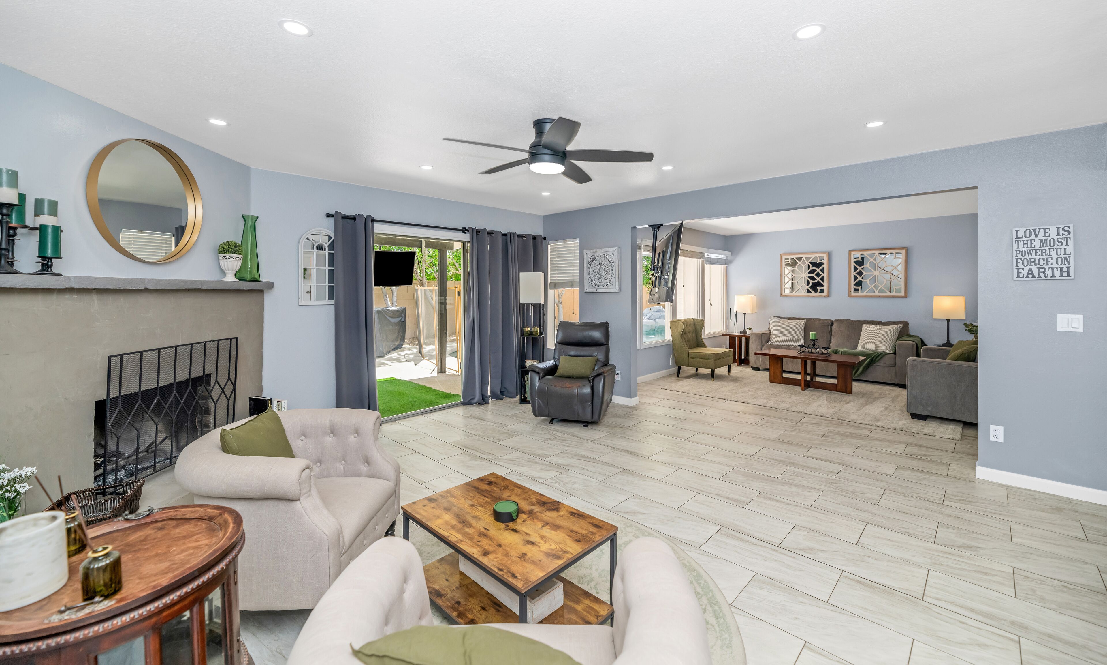 A spacious living area with a fireplace, seating, and a view to the outdoors.