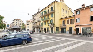 A street view with parked cars, buildings with balconies, and a pedestrian crossing. - COZY NEST IN THE HEART OF VERONA (Verona)