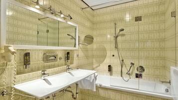 Un baño con lavamanos doble, un espejo grande, ducha y retrete.