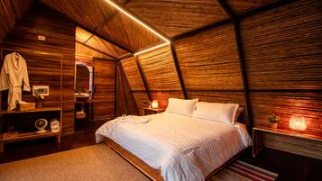 A cozy, wooden-themed bedroom with a large bed, bedside lamps, and a mirror.