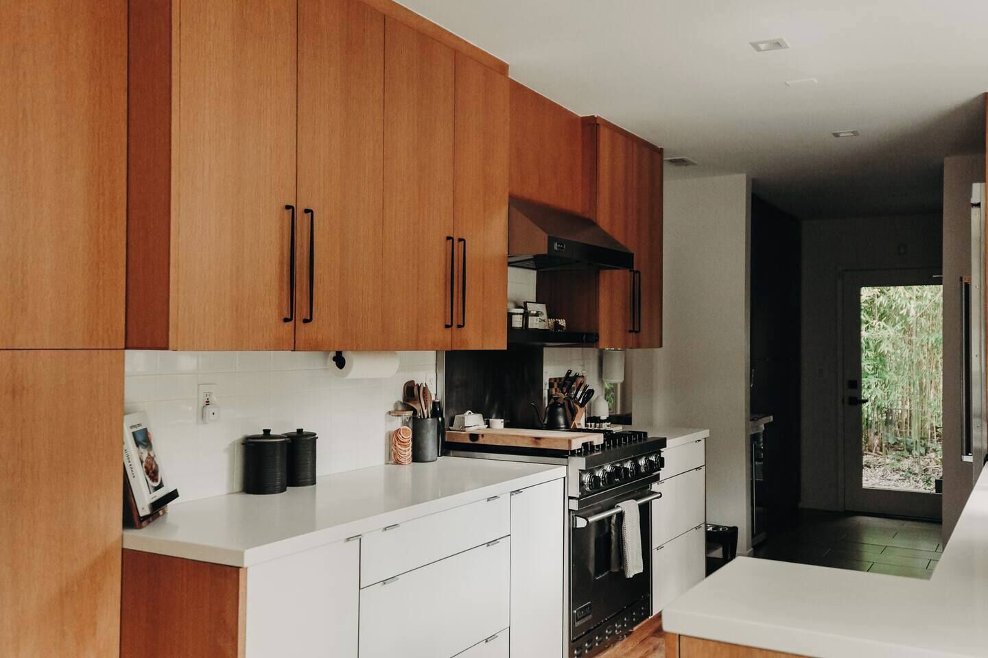 A modern kitchen with wooden cabinets, a white countertop, and a built-in stove.