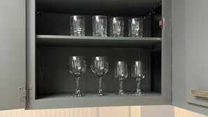 A kitchen with a microwave, a wooden table, and a cabinet with wine glasses. - Central Bellevue Retreat  (Bellevue)