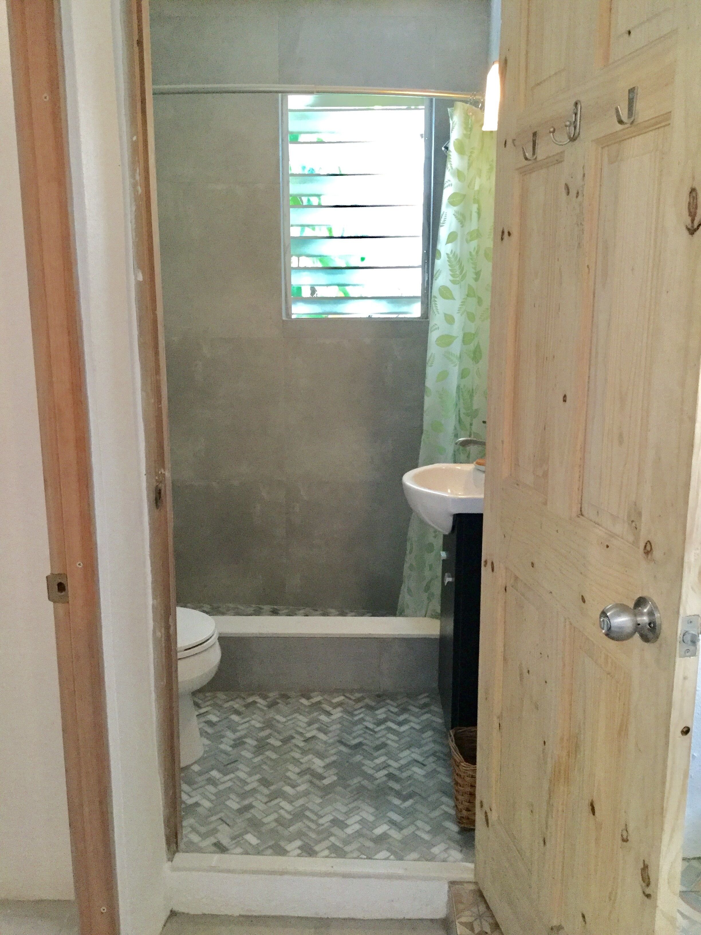 Une salle de bain avec douche, toilettes et lavabo.