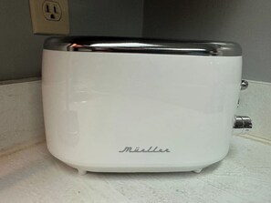 A white toaster with the brand name 'Müller' on it, placed on a countertop.