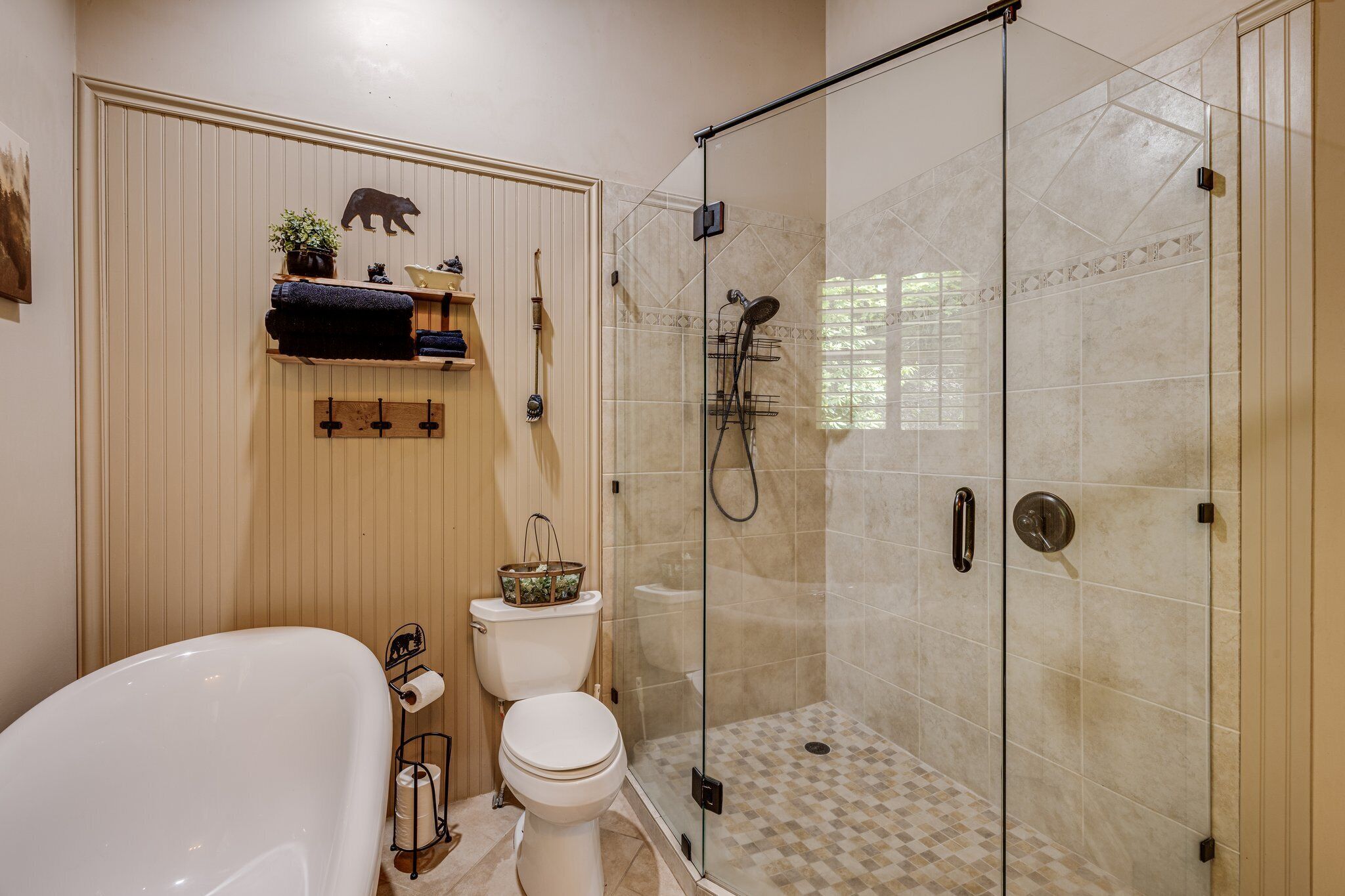 Ein Badezimmer mit Toilette, einer Glaskabine für die Dusche und Ablage für Toilettenartikel.
