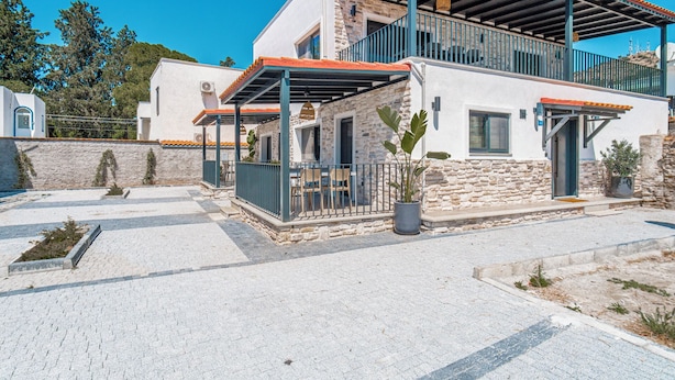 A modern two-story house with a stone facade, a balcony, and a covered outdoor seating area. - NewOld Flat Bodrum Marina 2+1 (Bodrum)