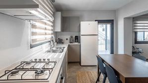 A modern kitchen with a gas stove, stainless steel sink, and a refrigerator. - NewOld Flat Bodrum Marina 2+1 (Bodrum)