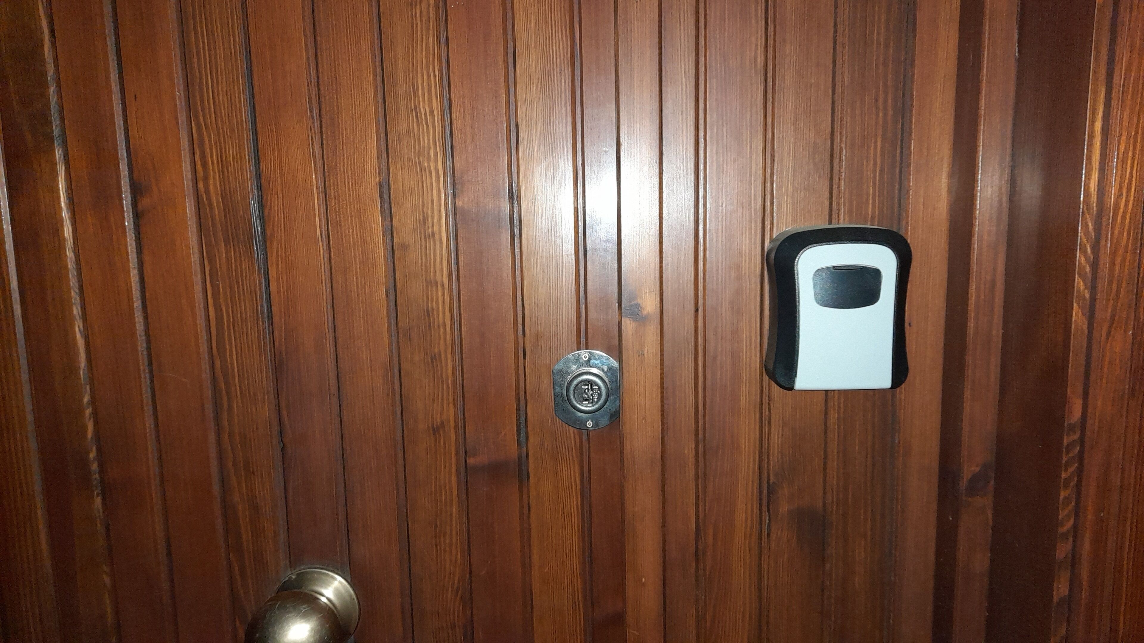 A wooden door with a keyhole and a doorbell.
