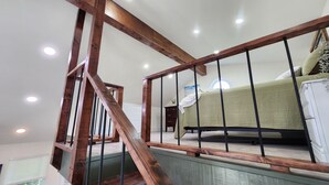 A bedroom with a wooden staircase, a bed, and a nightstand. - Welcome Home! Cozy, comfortable, quiet, secluded, private, beautiful. (Greenville)