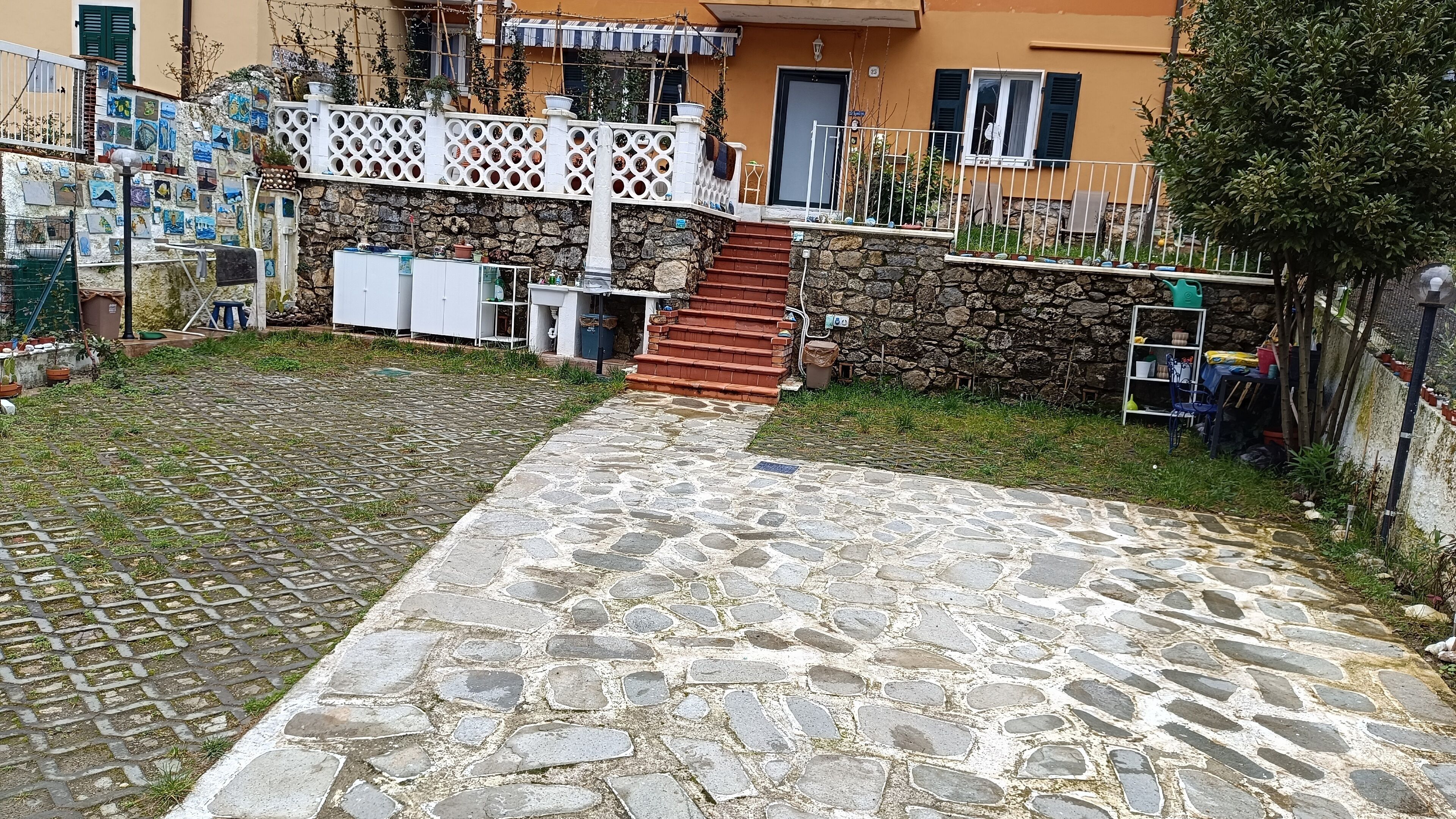 A courtyard with a stone pathway leading to a staircase.
