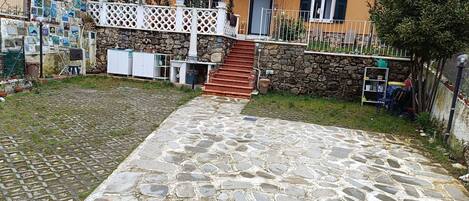 A courtyard with a stone pathway leading to a staircase.