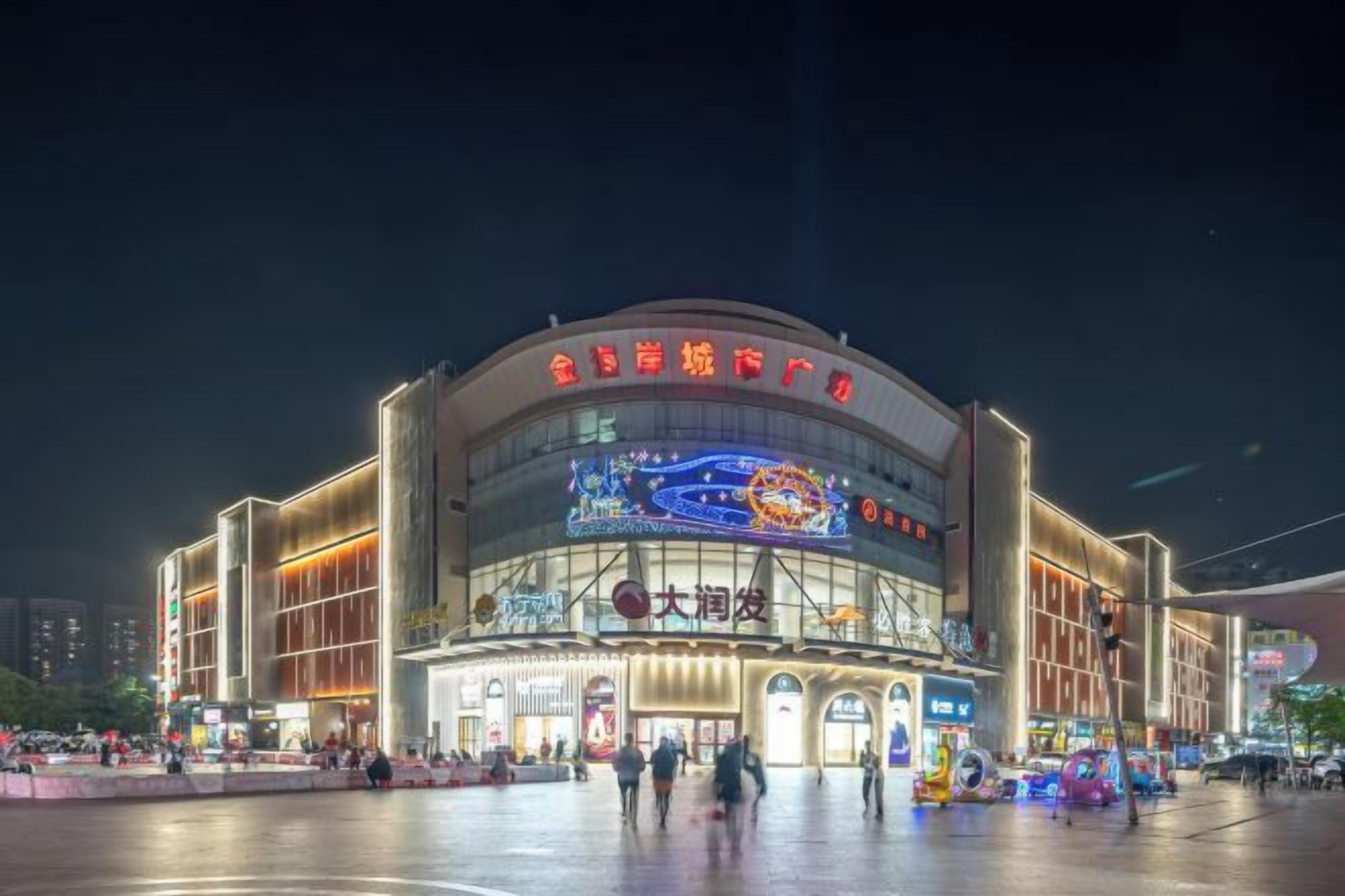 A large, illuminated building with a curved facade, multiple levels, and a prominent entrance.