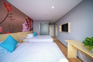 A hotel room with two beds, a desk, a TV, and a mural on the wall.