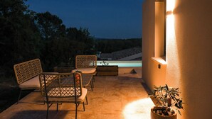 Un patio exterior con piscina, zona de estar y una planta en maceta.