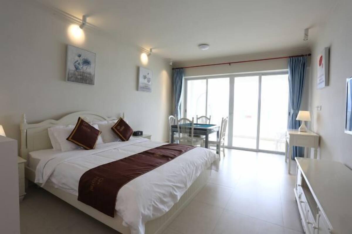 Una habitación de hotel con cama, escritorio, silla y balcón con vistas.
