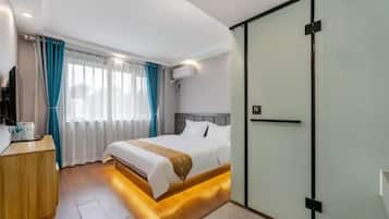 Une chambre d’hôtel moderne, équipée d’un lit, d’une table de chevet et d’une armoire.