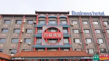 Un edificio con un letrero que dice 'Business hotel' y otro letrero con caracteres chinos.