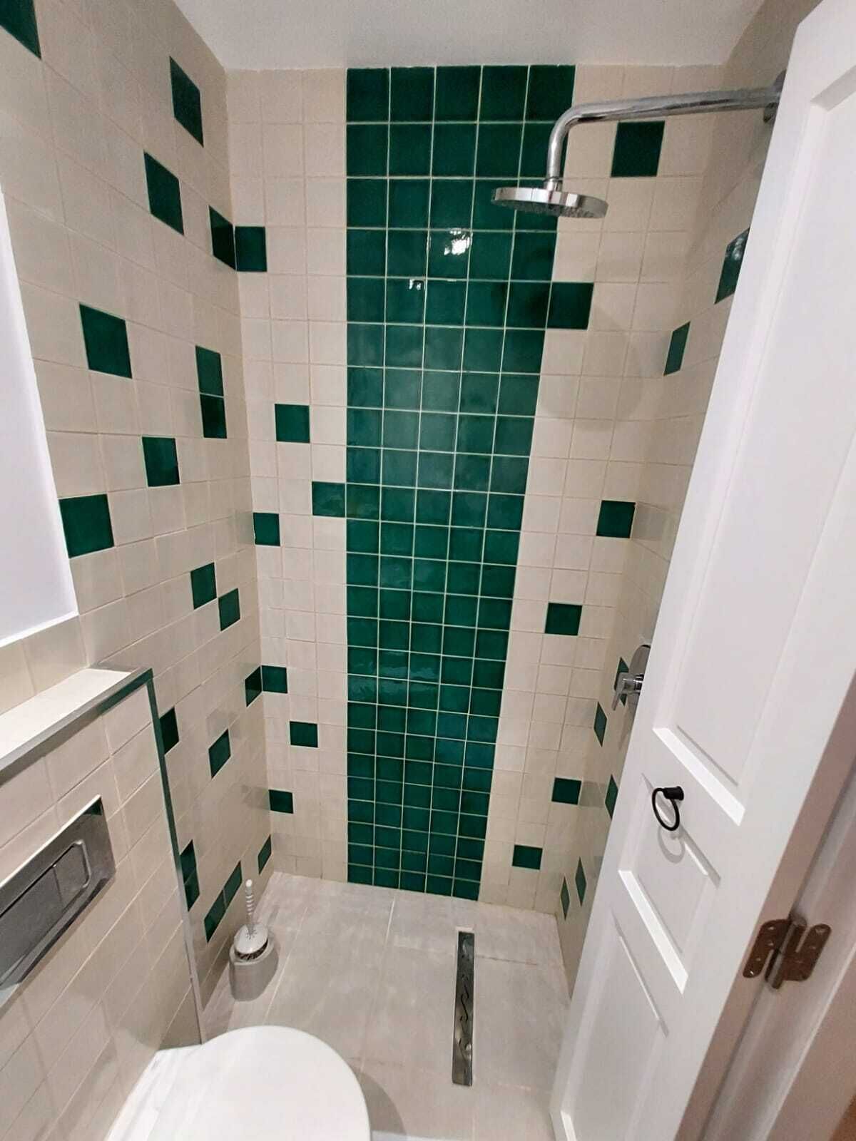A bathroom with a shower, toilet, and sink.
