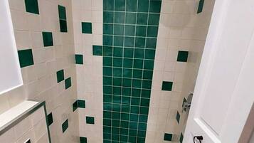 A bathroom with a shower, toilet, and sink.