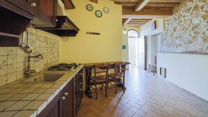 Une cuisine avec des meubles en bois, une cuisinière à gaz et un dosseret carrelé.