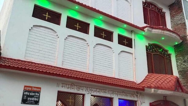 Ein mehrstöckiges Gebäude mit weißer Fassade, zahlreichen Fenstern mit Verziergittern und einem roten Ziegeldach.