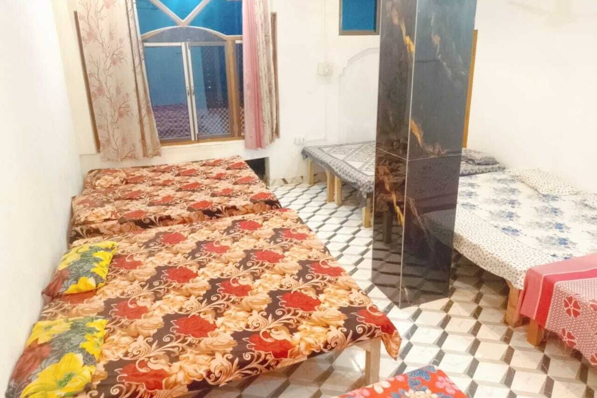 Una habitación con dos camas, una mesita y una ventana con cortinas.