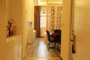 A hallway with a dining area, a water dispenser, and a door with a patterned curtain. - Tulip Fashion Hotel (Zhuquan Road Branch) (Zhaotong)