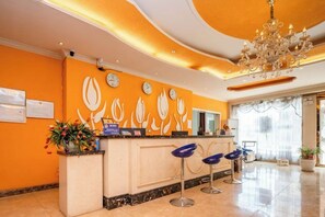 A hotel reception area with a marble counter, a chandelier, and a clock on the wall. - Tulip Fashion Hotel (Zhuquan Road Branch) (Zhaotong)