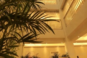 A multi-level indoor space with a central column, potted plants, and a ceiling with recessed lighting. - Tulip Fashion Hotel (Zhuquan Road Branch) (Zhaotong)