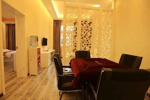 Une chambre d’hôtel comprenant un coin repas, un lit, un bureau, un distributeur d’eau et une télévision.