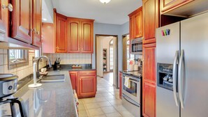 Una cocina moderna con armarios de madera, electrodomésticos de acero inoxidable y una isla central.
