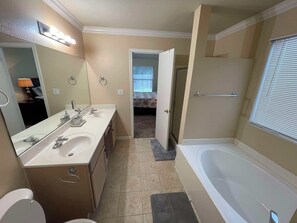 Ein Badezimmer mit Doppelwaschbecken, Toilette, Badewanne und Dusche.