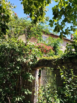 A stone bridge with a white fence, surrounded by lush greenery and flowering plants. - On the banks of the Tarn   (la cresse)